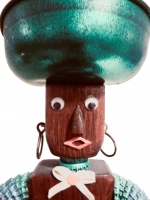Detail of orange and green legs on the brown bottle-cap figure with carved nose and mouth by the Oshkosh Master - vernacular art Detail of orange and green legs on the brown bottle-cap figure with carved nose and mouth by the Oshkosh Master - vernacular art