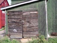 Exterior of shed covered  inside with bottle cap - vernacular art environment