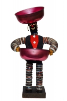 Black bottle-cap figure with felt vest and notebook reinforcers for eyes and mouth - vernacular art