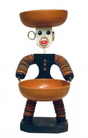 Black bottle-cap figure with tapered body and orange caps - vernacular art