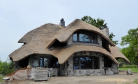 An early Earl Young house recently rebuilt into a more aggressive fairy tale style, complete with thatched roof, Charlevoix, Michigan