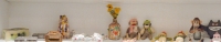 The bottom shelf from Chicago We Own It: Stanley Szwarc steel boxes, tramp art box, Harvey Ford sculpture, William Warmack bra, collaged jug, sock monkeys, crocheted Bert muppet dolls, monkey with cymbals, Nagua, Karl Wirsum Santa mask