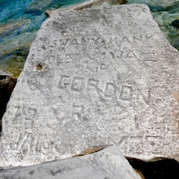 Autograph rock: NC, BE, Roy, heart, Swany Hank, Mr. Jackson, "44" 45 46 47, WA, Del, Ole, Gordon, GM, JAT, R, Moe, others. Chicago lakefront stone carvings, behind La Rabida Hospital. 2026