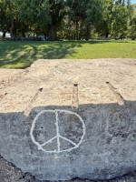Peace symbol, sun. Made at the June 20, 2026, DIY carving workshop. Chicago lakefront stone carvings, Promontory Point. 2026