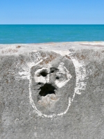 Face made using existing rock form, probably by Joel Cardenas in 2026. Chicago lakefront stone carvings, Promontory Point. 2026