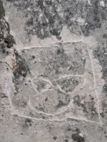 Comic face. Made at the June 20, 2026, DIY carving workshop on the "Free Palestine" rock. Chicago lakefront stone carvings, Promontory Point. 2026