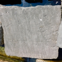 Smiley face, Dan, Scott, Oink, 68, detail. Chicago lakefront stone carvings, Rainbow Beach jetty. 2022