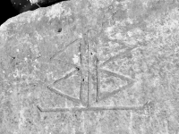 Symbol. Perhaps a monogram (BB) or perhaps a flag. Chicago lakefront stone carvings, Rainbow Beach jetty. 2022