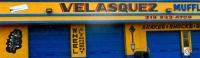 Velasquez Muffler with sign and auto parts painted the wall