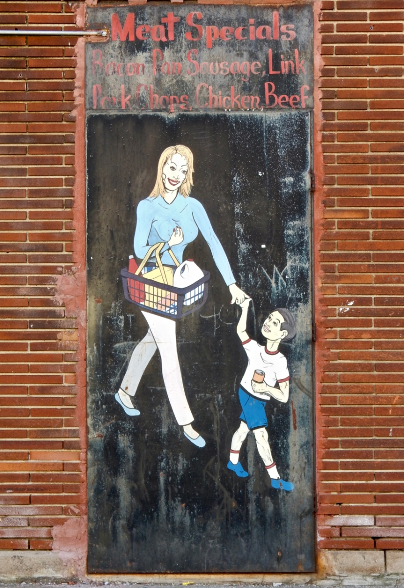 Woman and child with groceries from the outdoor art gallery at Las Americas Food and Liquor